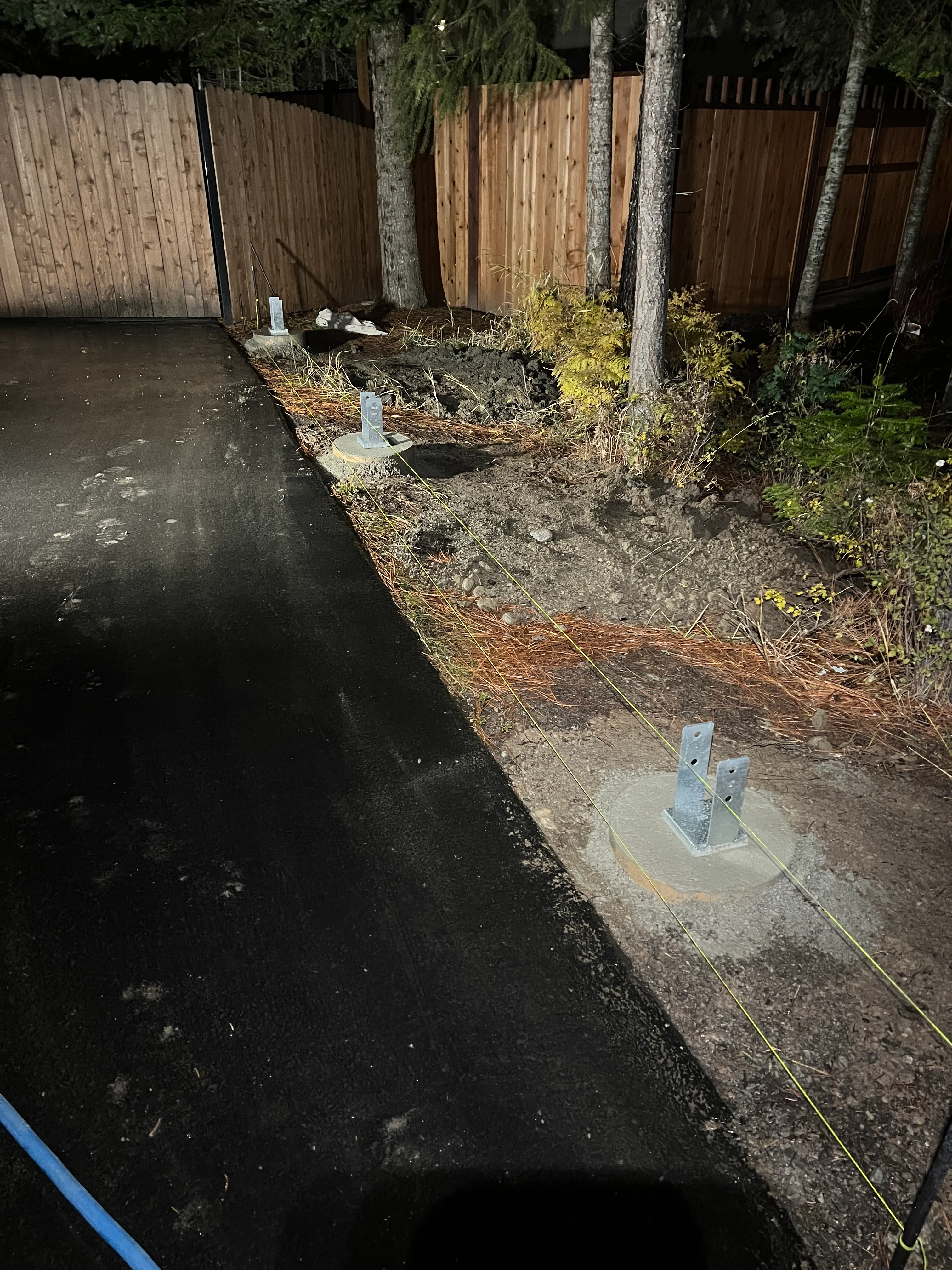 Concrete footings and post hardware being set