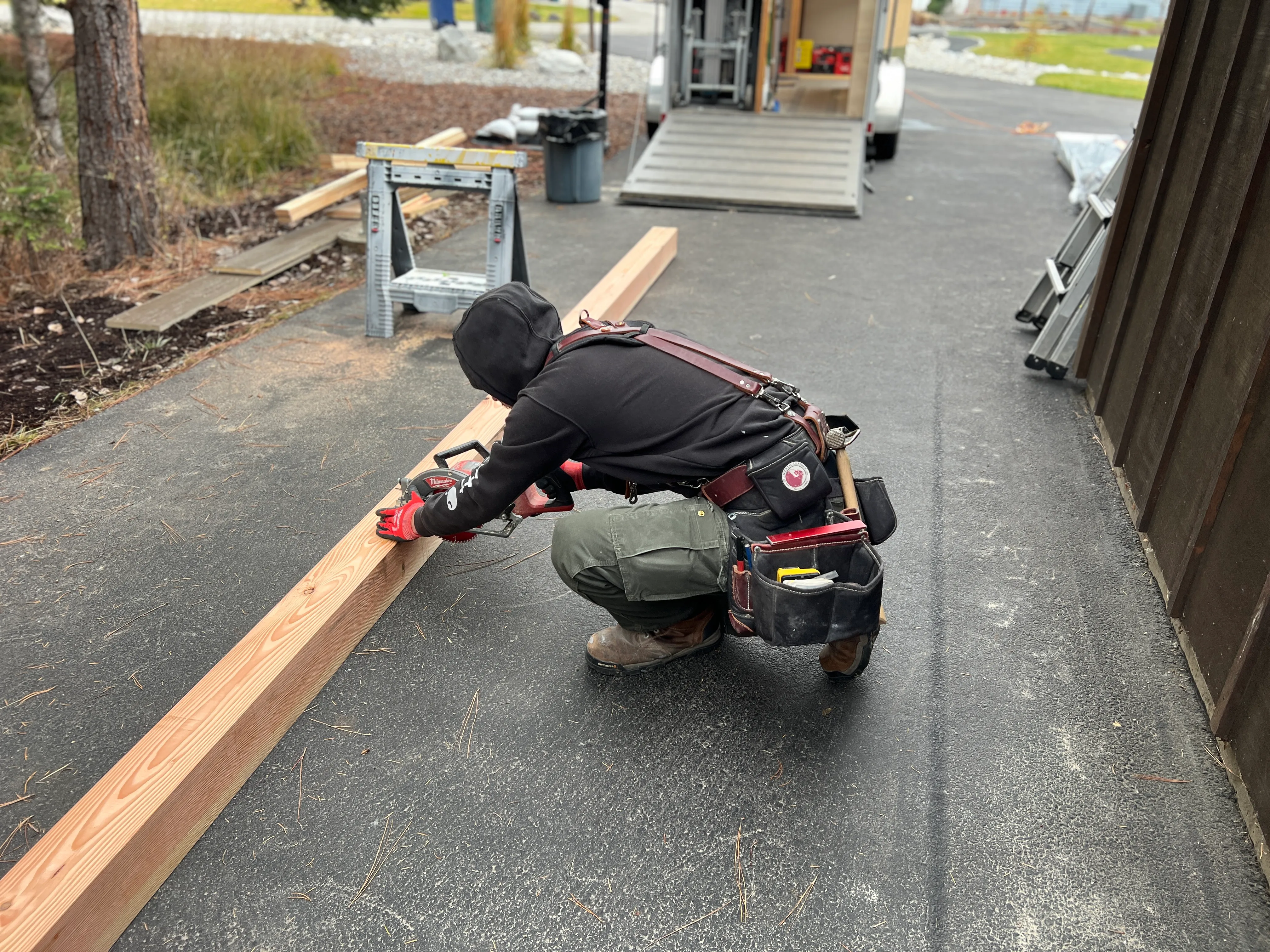 Contractor cutting and measuring timber framing