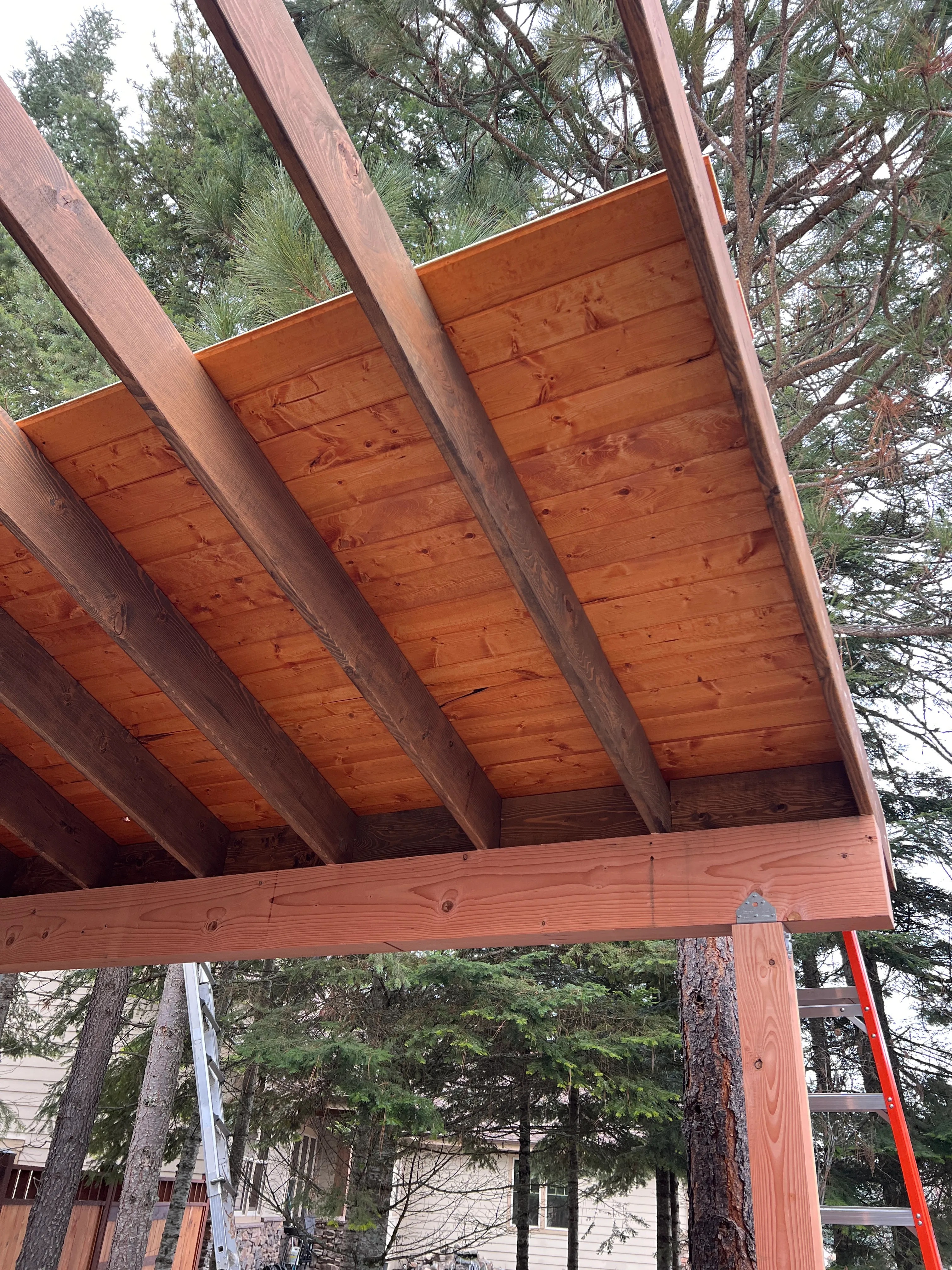 Cedar deck boards installed on lean-to roof