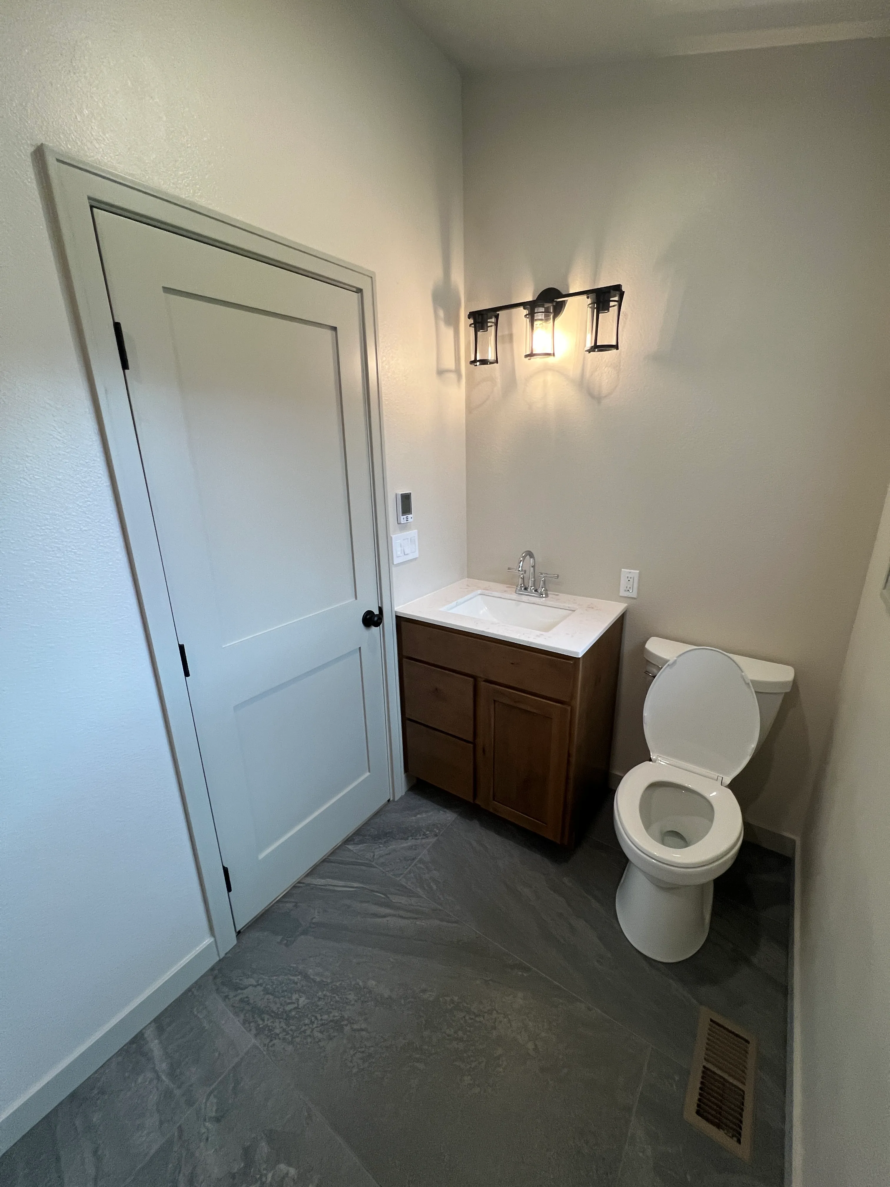 Completed bathroom with lit wall sconces