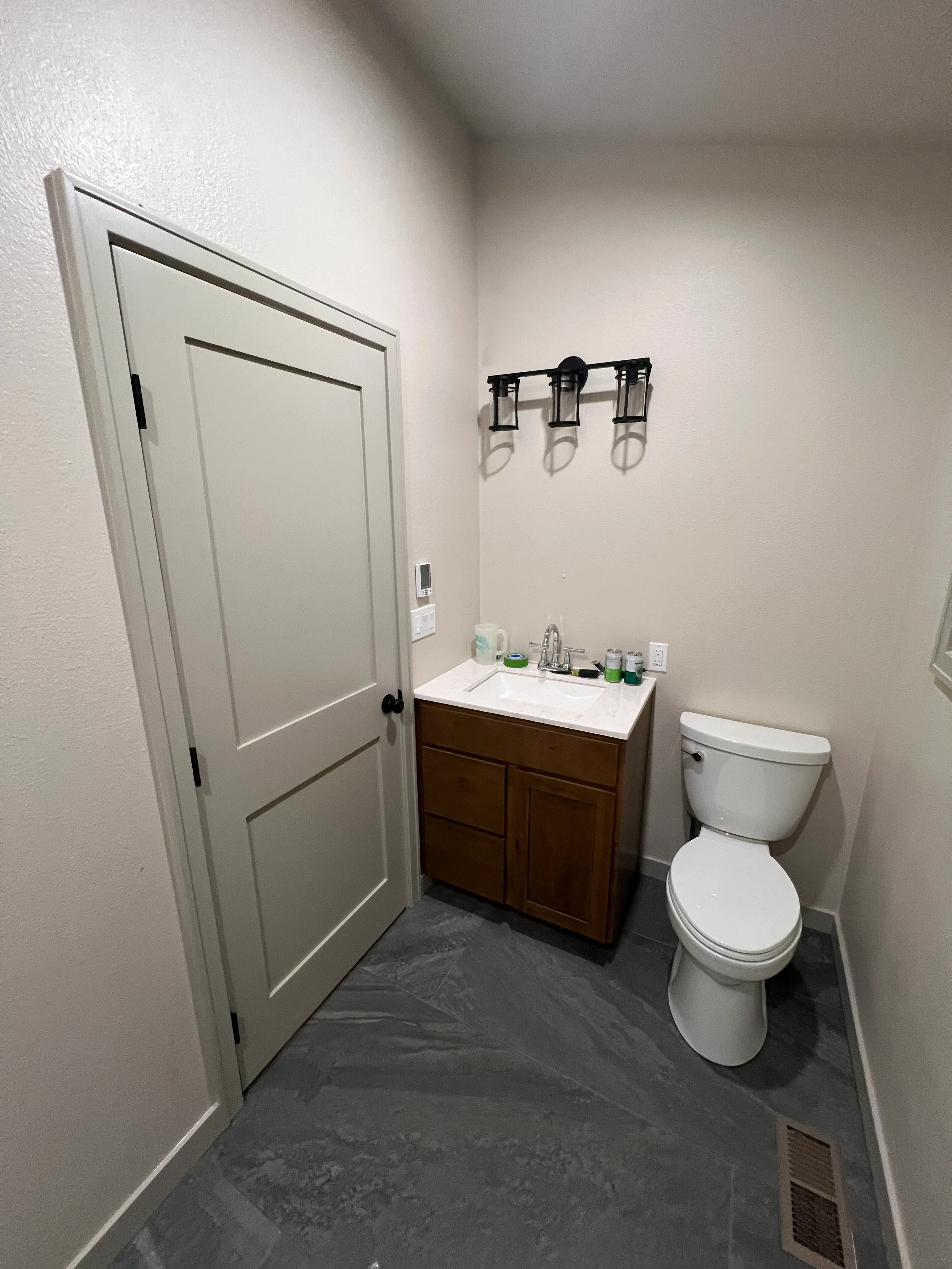 Finished toilet area with vanity and sconce lighting