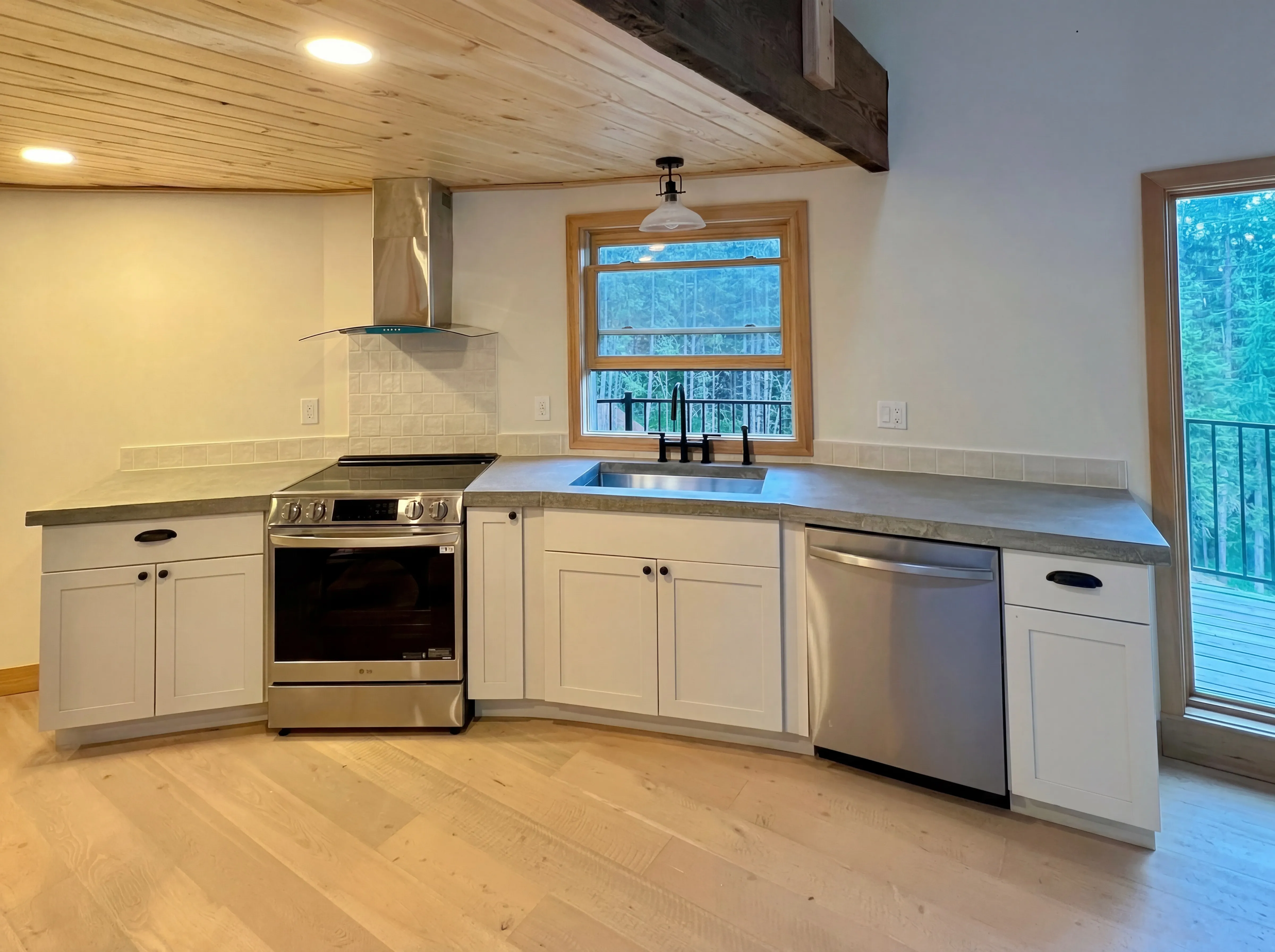 Completed yurt kitchen with concrete countertops and wood ceiling
